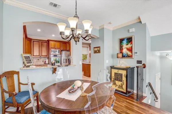a view of a dining room with furniture a chandelier and wooden floor