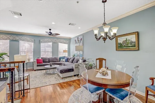 a living room with furniture a chandelier and a dining table