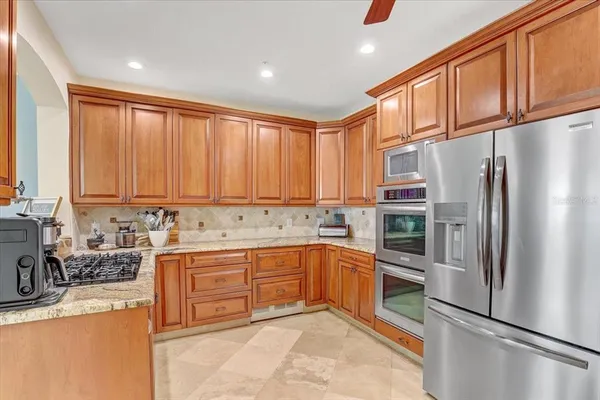 a kitchen with stainless steel appliances granite countertop a refrigerator sink and cabinets