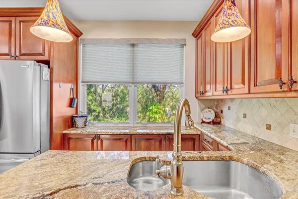 a kitchen with stainless steel appliances granite countertop a sink stove and refrigerator