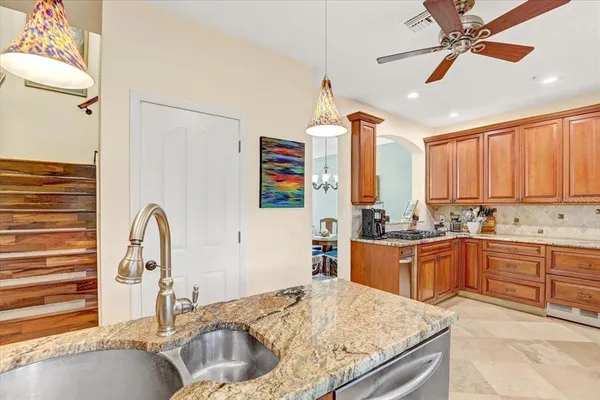 a kitchen with stainless steel appliances granite countertop a sink a stove and a refrigerator