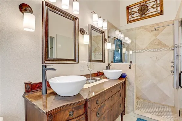 a bathroom with a granite countertop sink mirror and a window