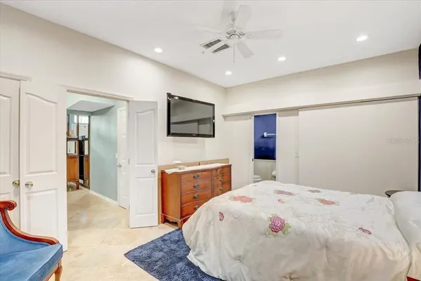 a spacious bedroom with a bed and a flat screen tv