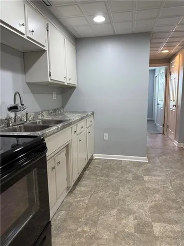 a kitchen with granite countertop a stove sink and cabinets