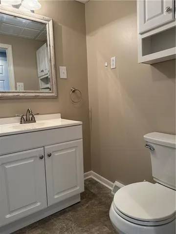 a bathroom with a toilet a sink and mirror