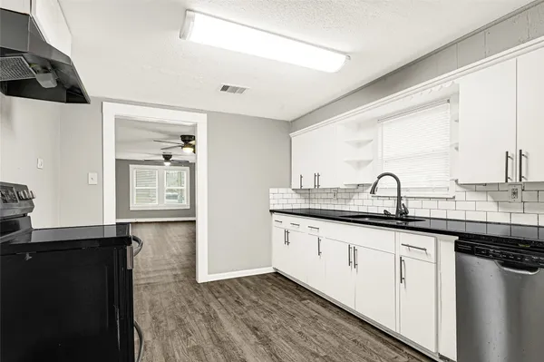 a kitchen with granite countertop a sink and cabinets