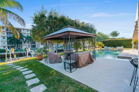 a view of patio with table and chairs under an umbrella