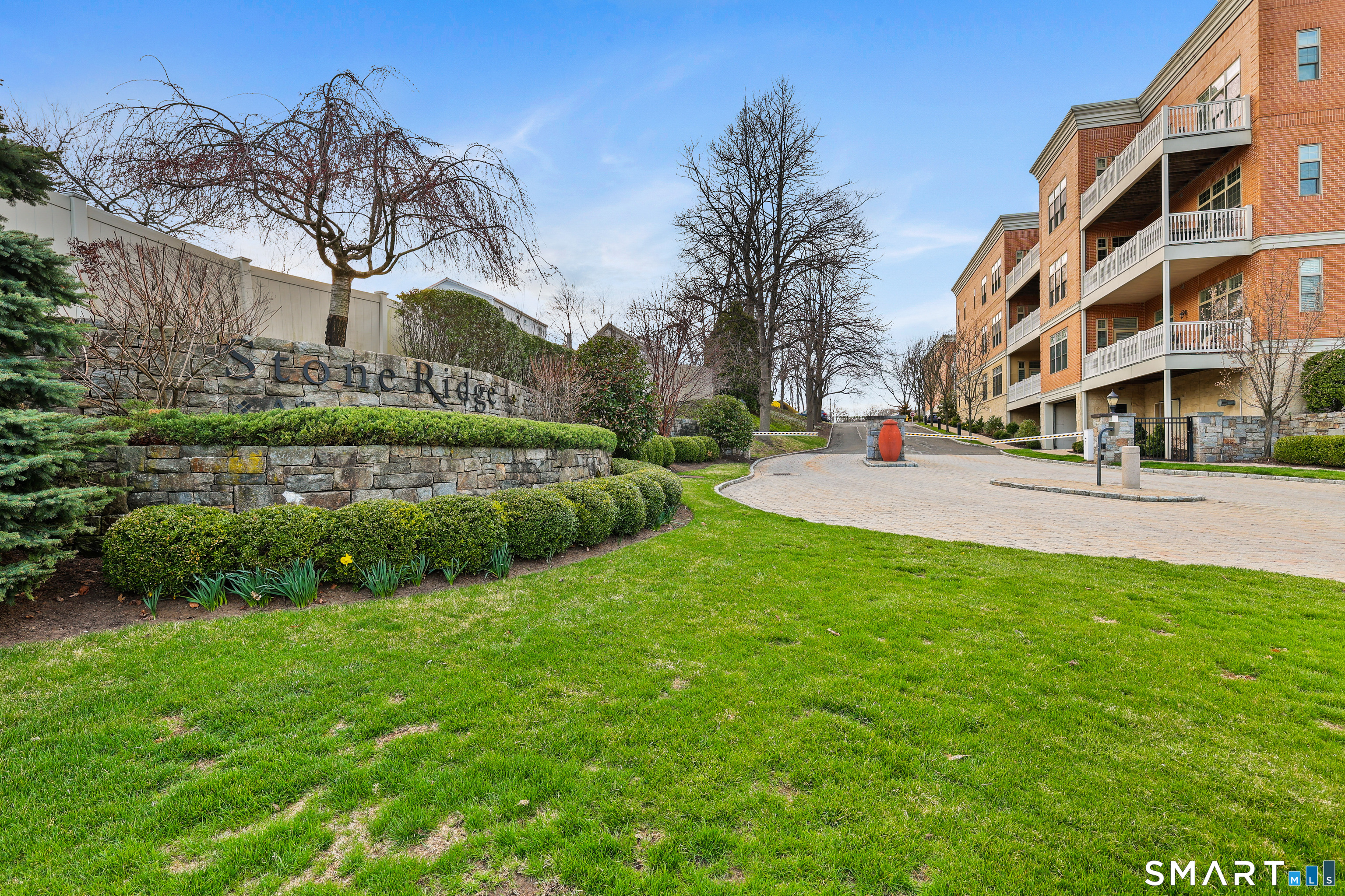 50 Stone Ridge Way, Unit 2A Fairfield, CT 06824 - Photo 1 of 36 a view of a building with a big yard and large trees