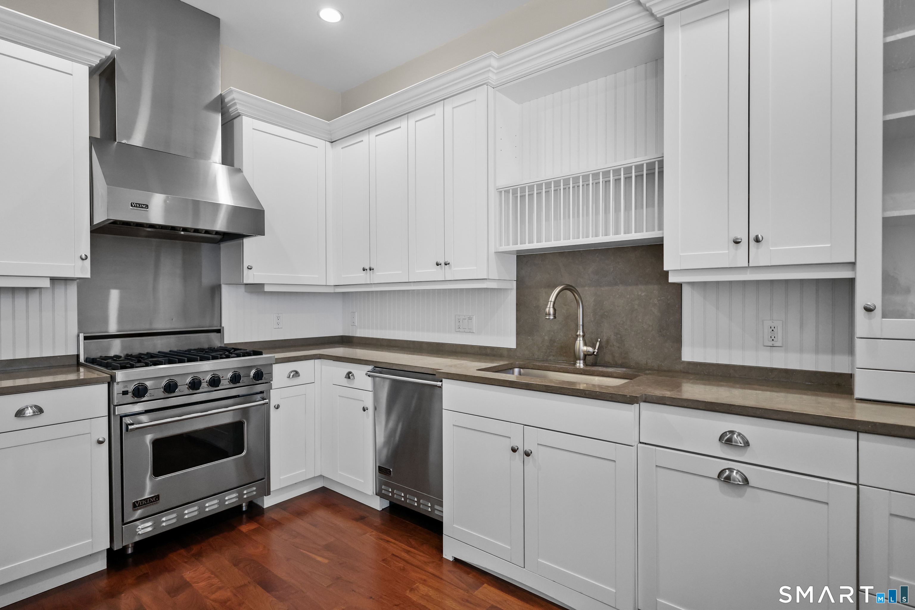 50 Stone Ridge Way, Unit 2A Fairfield, CT 06824 - Photo 7 of 36 a kitchen with granite countertop a stove a sink and dishwasher with white cabinets