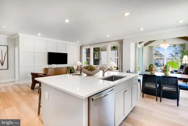 a open kitchen with stainless steel appliances kitchen island a sink table and chairs