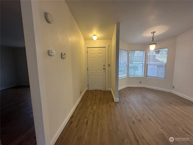 a view of a hallway with wooden floor and a fireplace