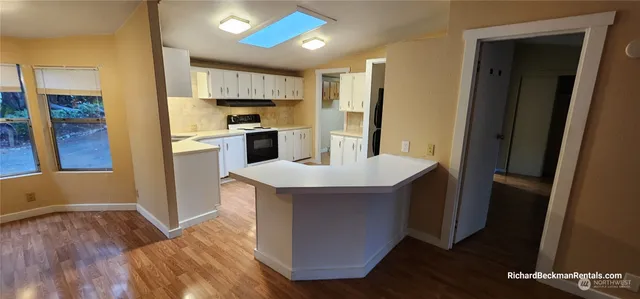 a kitchen with granite countertop a refrigerator and a stove top oven