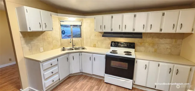 a kitchen with white cabinets and white appliances