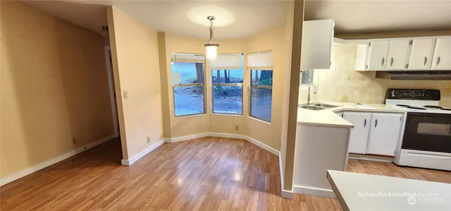 a kitchen with stainless steel appliances granite countertop a refrigerator a stove and a wooden floors