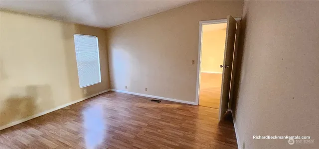 a view of an empty room with wooden floor