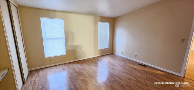 an empty room with wooden floor and closet
