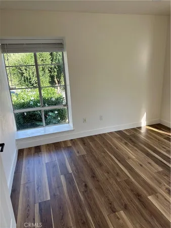 a view of a room with wooden floor and window