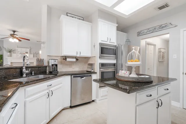 a kitchen with stainless steel appliances granite countertop a sink and cabinets