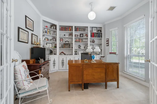 a living room with furniture a bookshelf and a window