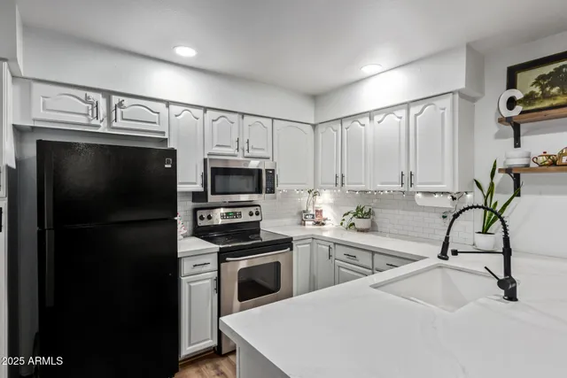 a kitchen with stainless steel appliances a sink cabinets and a refrigerator