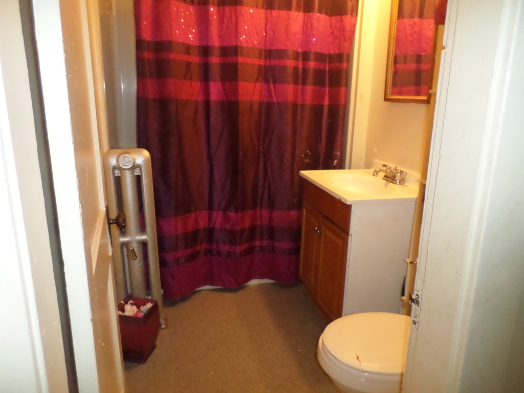 60-62 Merida Street Springfield, MA 01104 - Photo 8 of 22 a bathroom with a sink a toilet a tub and shower curtain