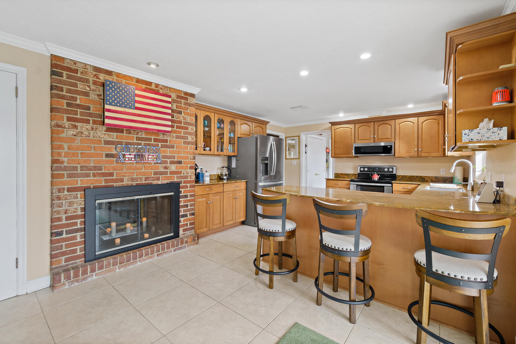 560 Capri Road Cocoa Beach, FL 32931 - Photo 18 of 31 a kitchen with microwave a stove and chairs
