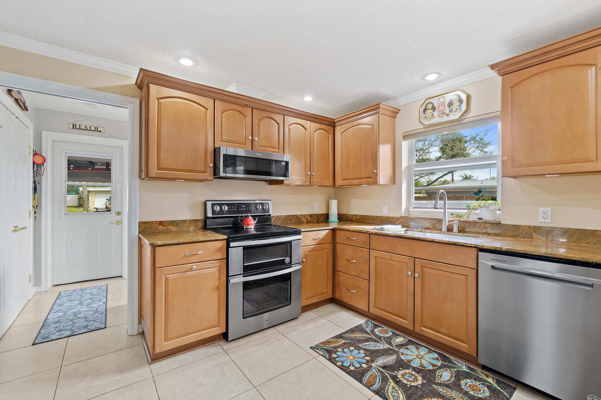 560 Capri Road Cocoa Beach, FL 32931 - Photo 19 of 31 a kitchen with stainless steel appliances granite countertop a sink stove and refrigerator