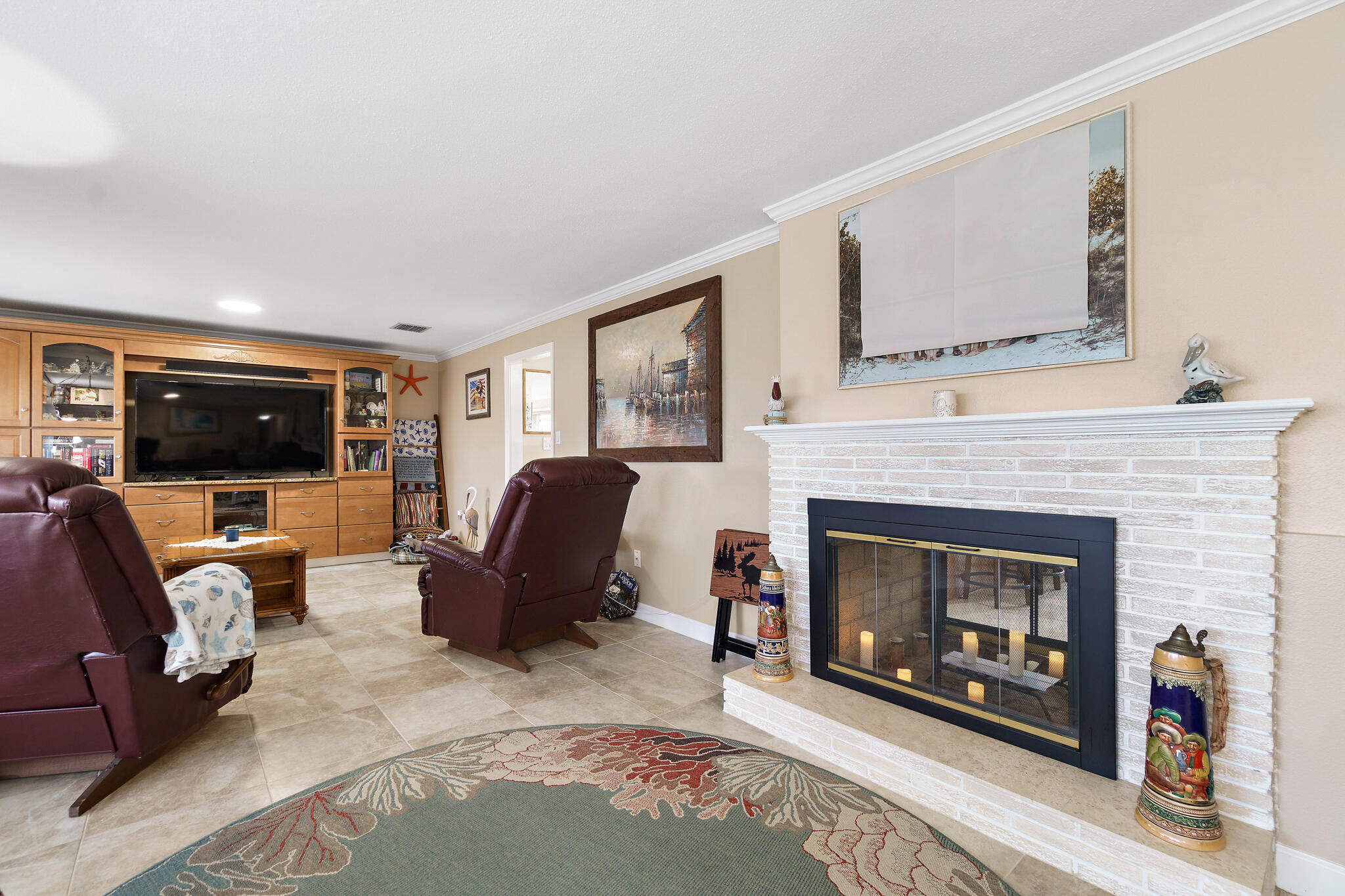 560 Capri Road Cocoa Beach, FL 32931 - Photo 22 of 31 a living room with furniture a flat screen tv and a fireplace