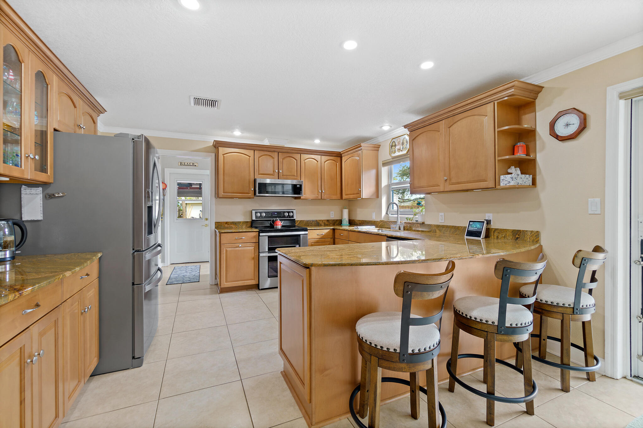 560 Capri Road Cocoa Beach, FL 32931 - Photo 6 of 31 a kitchen with cabinets and chairs