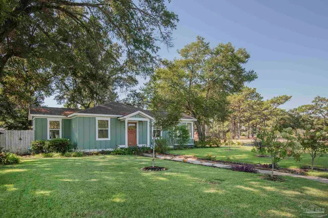 a front view of house with yard and green space