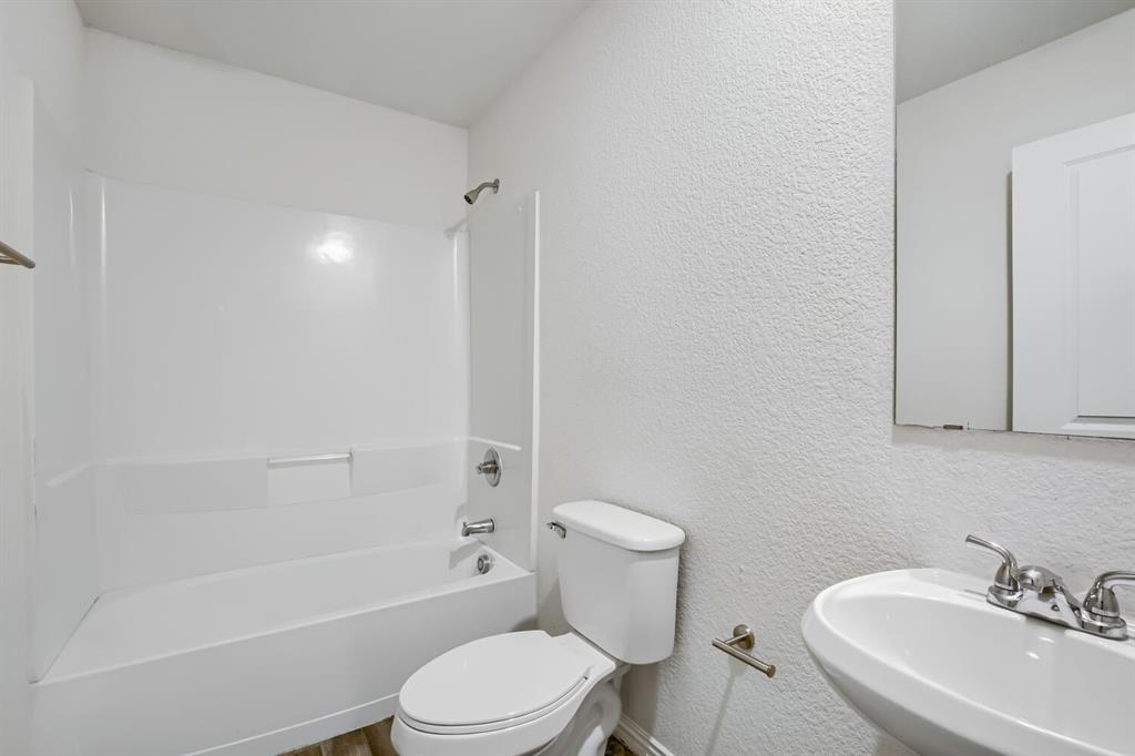 903 Olive Street Waco, TX 76704 - Photo 15 of 15 a bathroom with a toilet a sink and bathtub