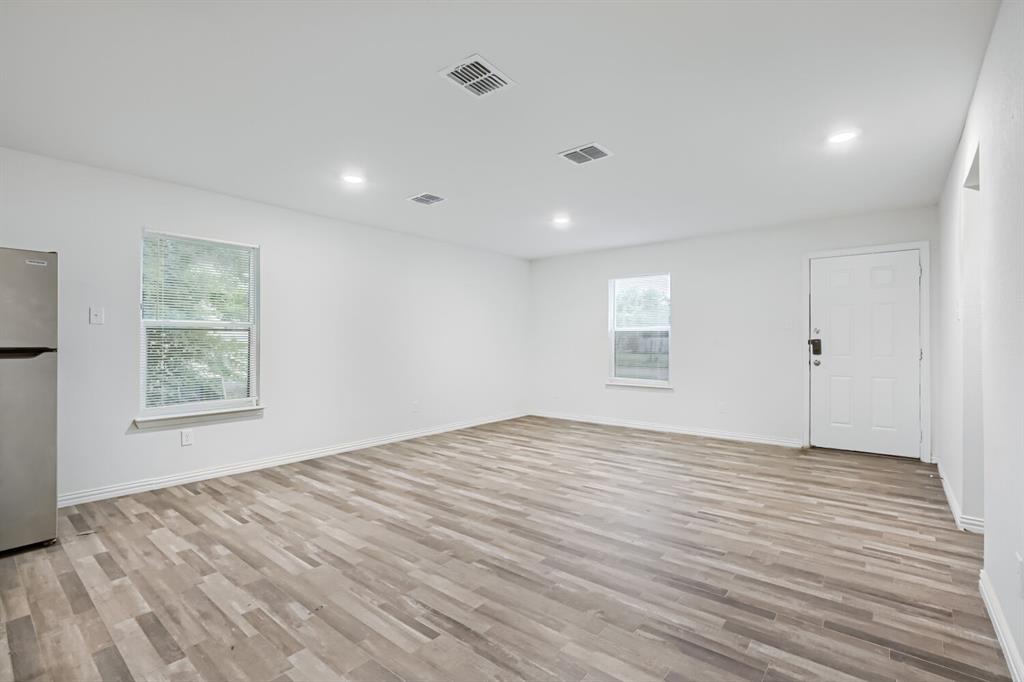 903 Olive Street Waco, TX 76704 - Photo 7 of 15 a view of an empty room with wooden floor and a window