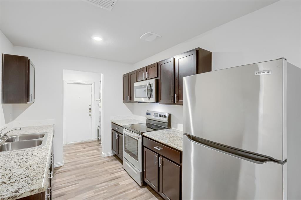 903 Olive Street Waco, TX 76704 - Photo 8 of 15 a kitchen with stainless steel appliances a refrigerator stove and sink