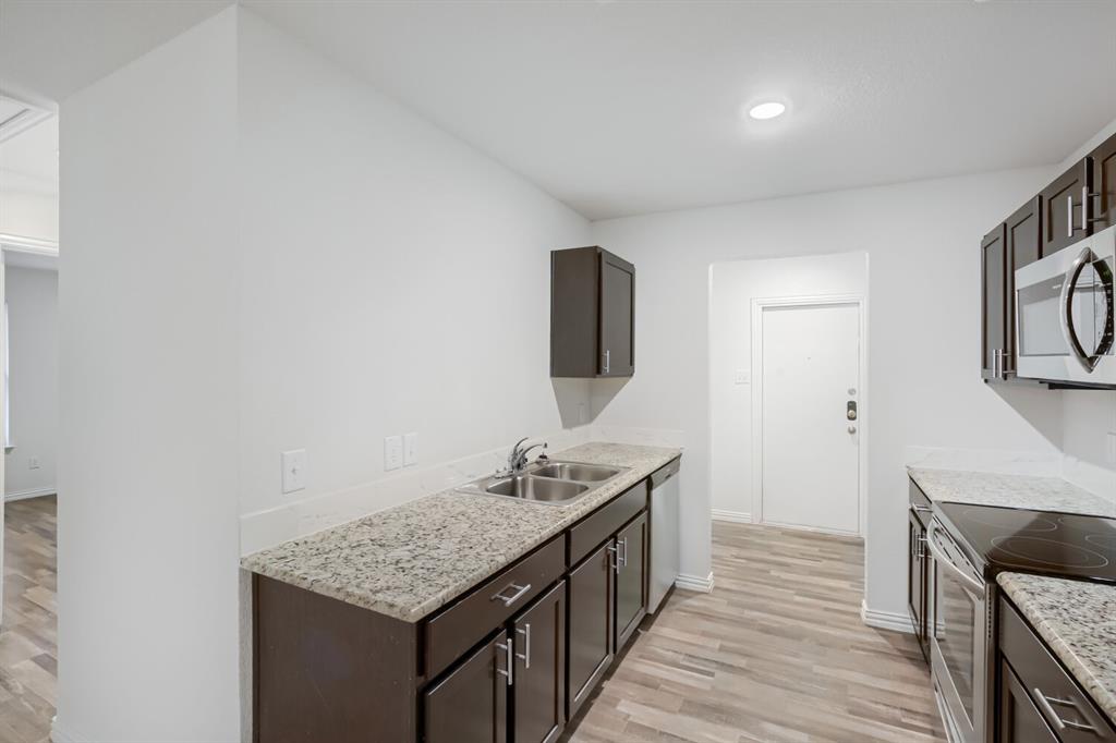903 Olive Street Waco, TX 76704 - Photo 9 of 15 a bathroom with a granite countertop sink a mirror and vanity