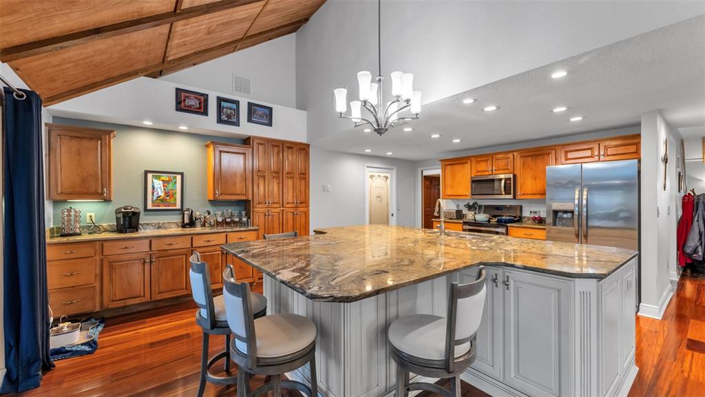 1804 Michelle Lane Lakeland, FL 33813 - Photo 26 of 83 a kitchen with stainless steel appliances granite countertop wooden floor a dining table and chairs