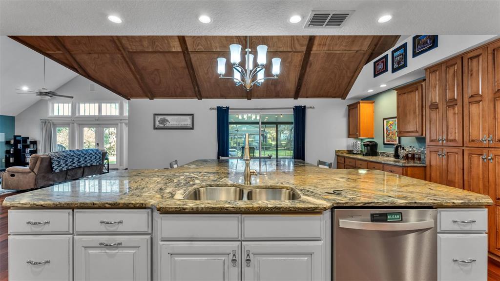 1804 Michelle Lane Lakeland, FL 33813 - Photo 29 of 83 a kitchen with granite countertop a sink and white cabinets next to a window