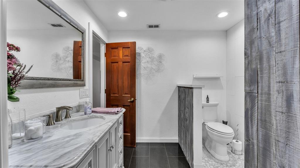 1804 Michelle Lane Lakeland, FL 33813 - Photo 46 of 83 a bathroom with a granite countertop sink toilet and shower curtains