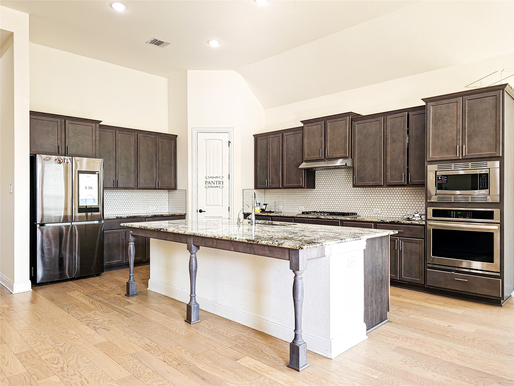 813 Sunny Ridge Drive Leander, TX 78641 - Photo 10 of 32 Culinary delights await in this modern kitchen featuring a vast granite island and contemporary appliances.