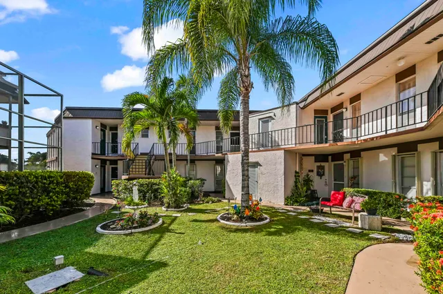 front view of house with a yard and potted plants