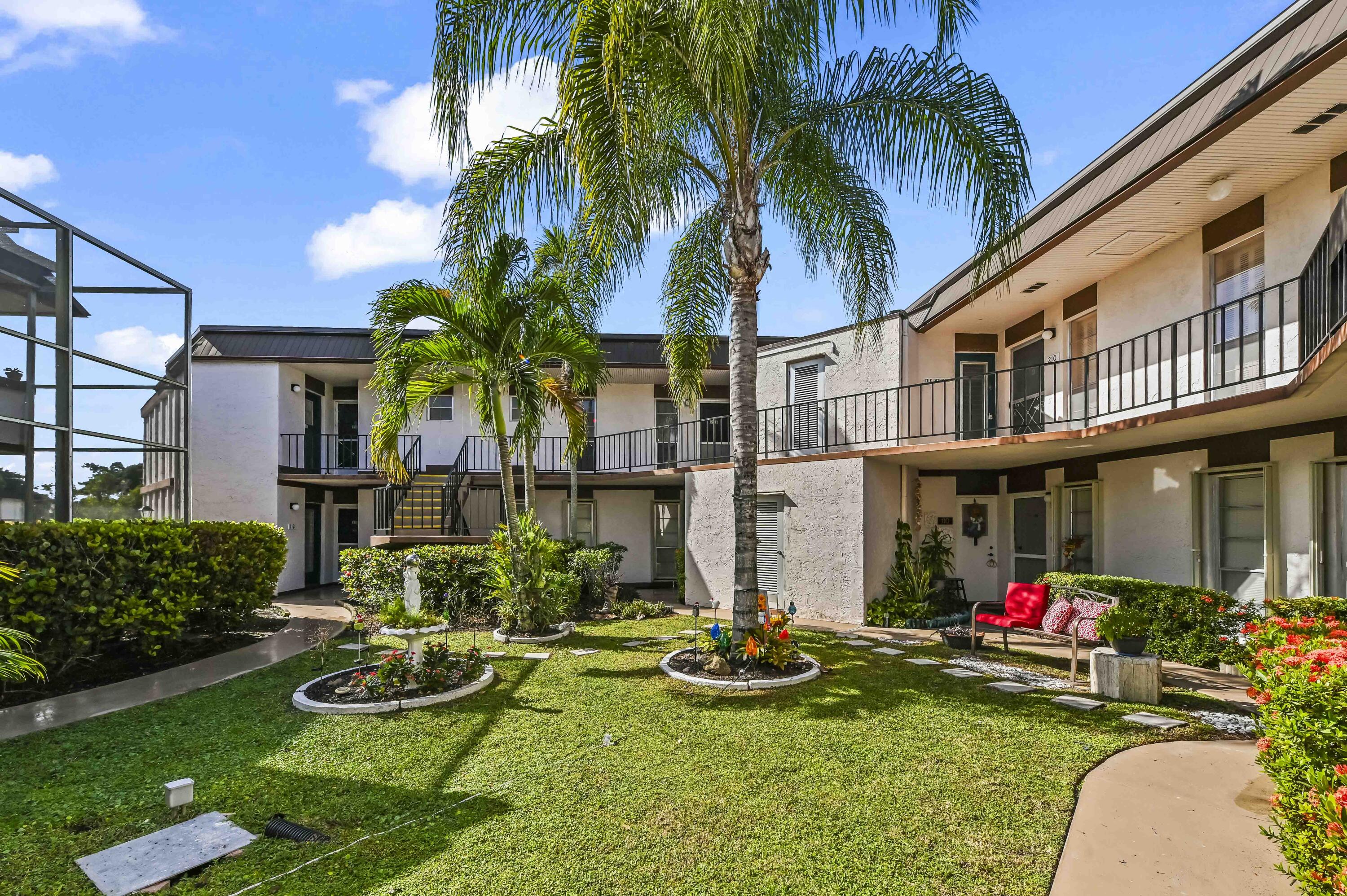 front view of house with a yard and potted plants