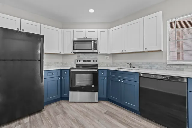 a kitchen with granite countertop cabinets stainless steel appliances and a sink