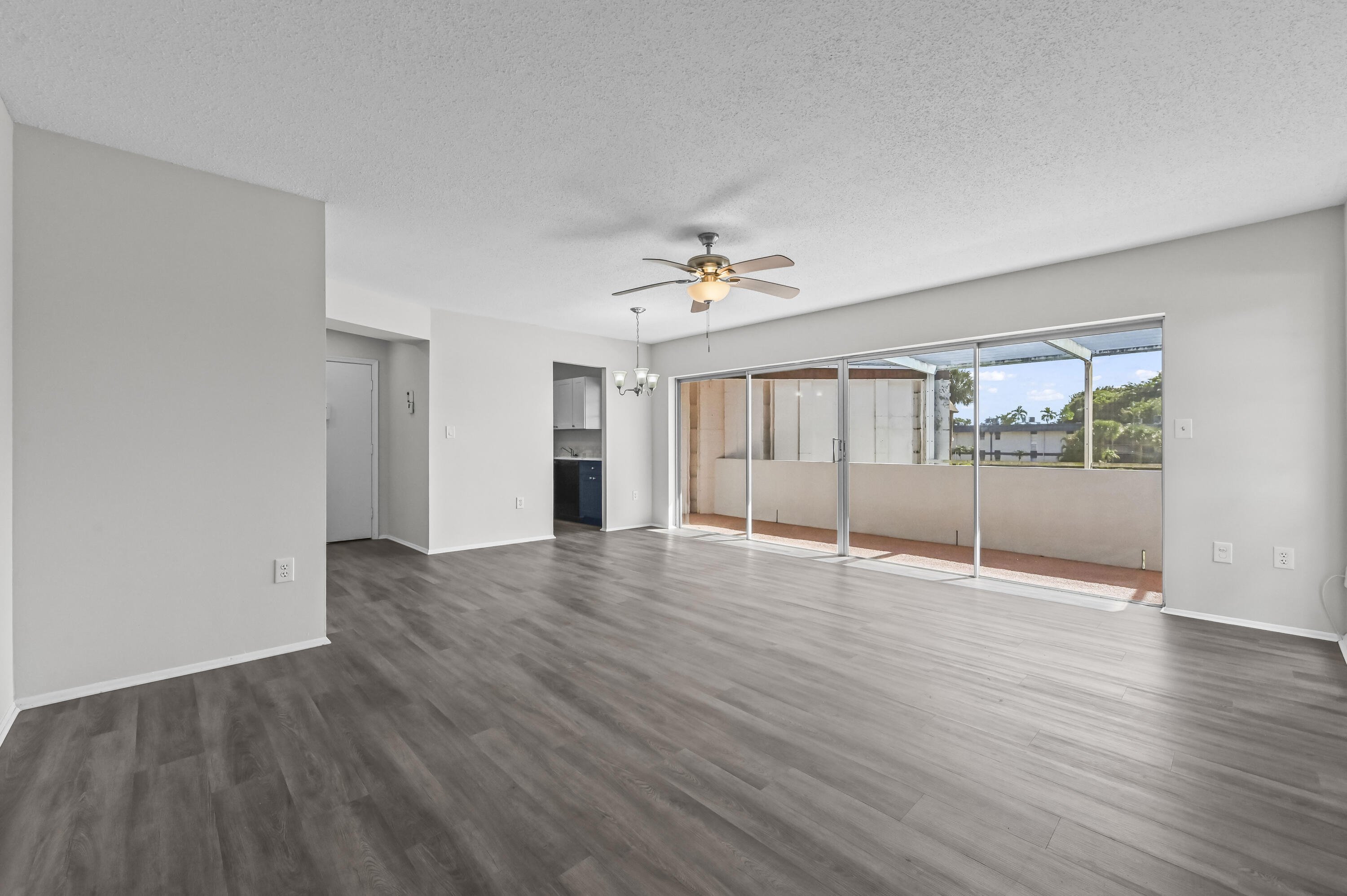6 Greenway N Royal Palm Beach North, Unit 212 Royal Palm Beach, FL 33411 - Photo 3 of 23 a view of an empty room with wooden floor and a window