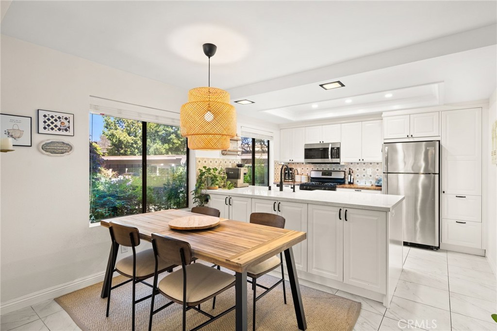 374 South Prospectors Road, Unit 121 Diamond Bar, CA 91765 - Photo 8 of 36 a kitchen with stainless steel appliances granite countertop a table chairs and a refrigerator