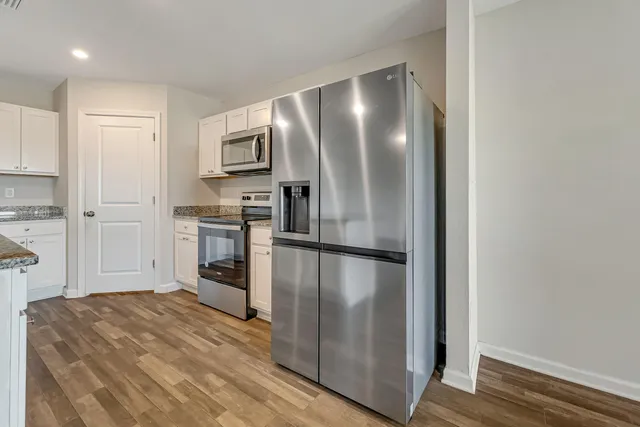 a kitchen with stainless steel appliances a refrigerator and microwave