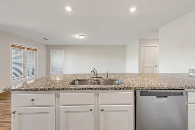a kitchen with granite countertop cabinets and window