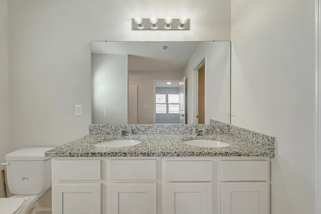 a bathroom with a granite countertop sink and a mirror
