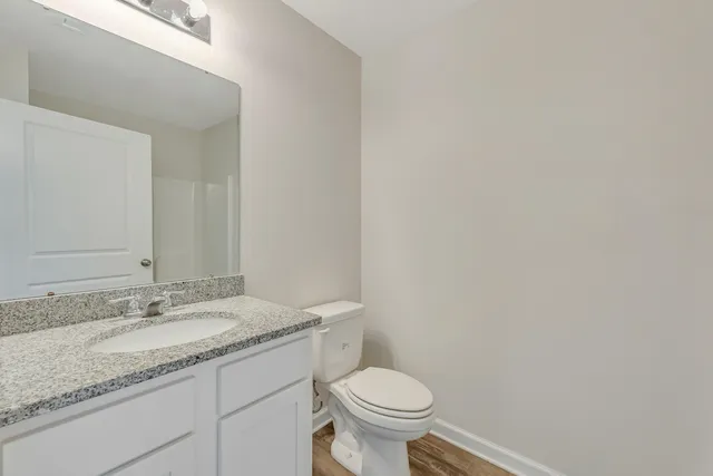 a bathroom with a granite countertop sink and a toilet