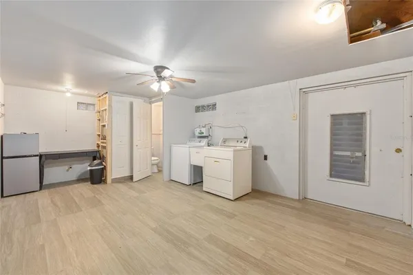 a view of a kitchen with refrigerator and wooden floor