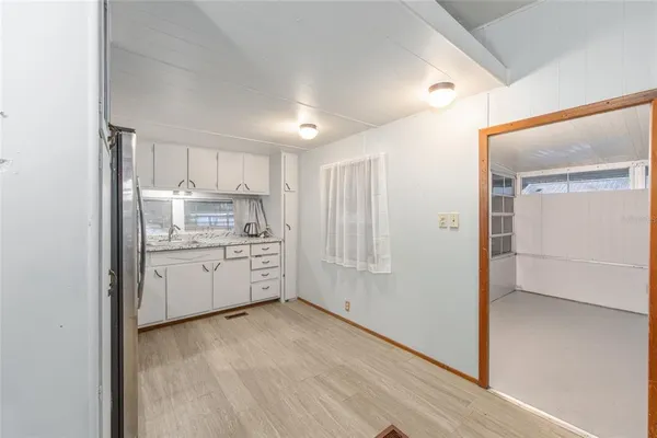 a kitchen with white cabinets and white appliances