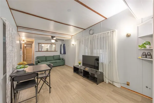 a living room with furniture a flat screen tv and a window
